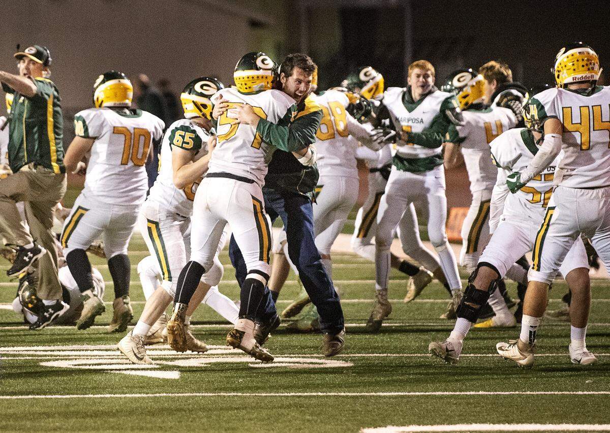 Mariposa players and coaches celebrate their 17-14 victory over Denair in the Sac-Joaquin Section Division VII championship game on Friday at Turlock High School in Turlock, Calif., Friday, Nov. 22, 2019.