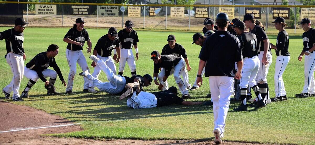 The Buhach Colony High players watch as coaches Greg Wakefield near and Joe Medeiros slide into the grass to celebrate a 6-2 playoff win over Rio Americano on Friday, May 17, 2019.
