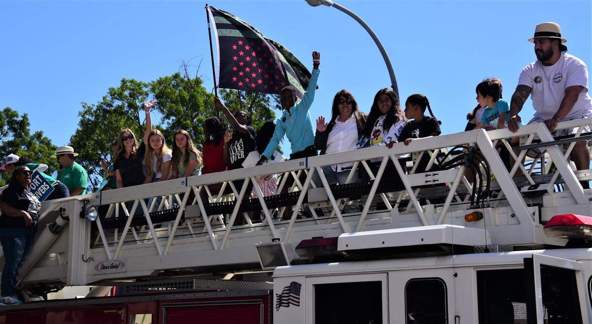 People climb atop a fire engine during the first Juneteenth Parade in Merced, Calif. on Saturday, June 18, 2022.
