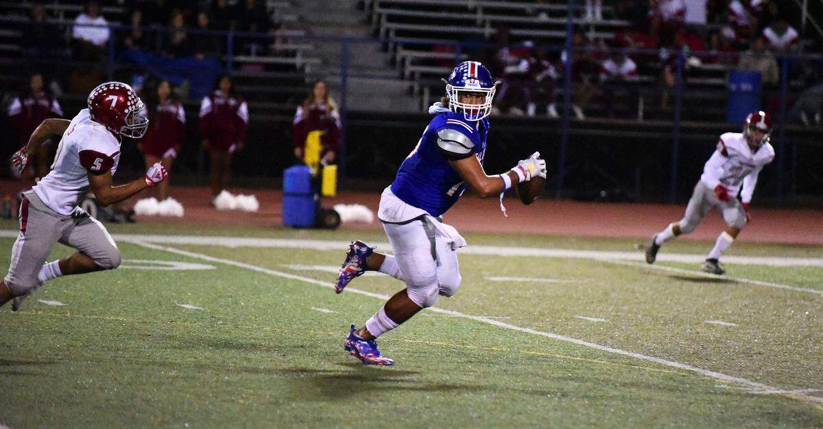 Atwater tight end Xavier Williams peaks over his shoulder at Patterson defensive back Obadiah Godbolt during Friday ngiht’s game at Dave Honey Stadium in Atwater, Calif.