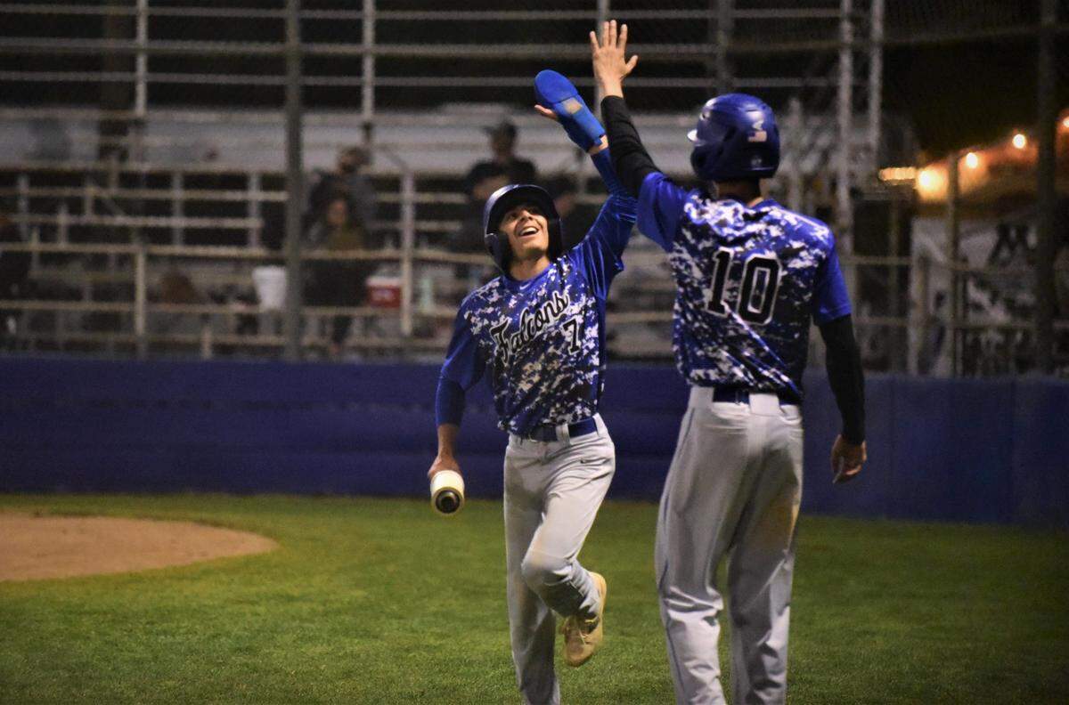 Atwater High’s Xavier Cardenas celebrates after scoring a run with teammate KJ Ross during a Falcons’ 8-6 win over Mountain House on Tuesday, April 19, 2022 at Memorial Ballpark in Atwater, Calif.