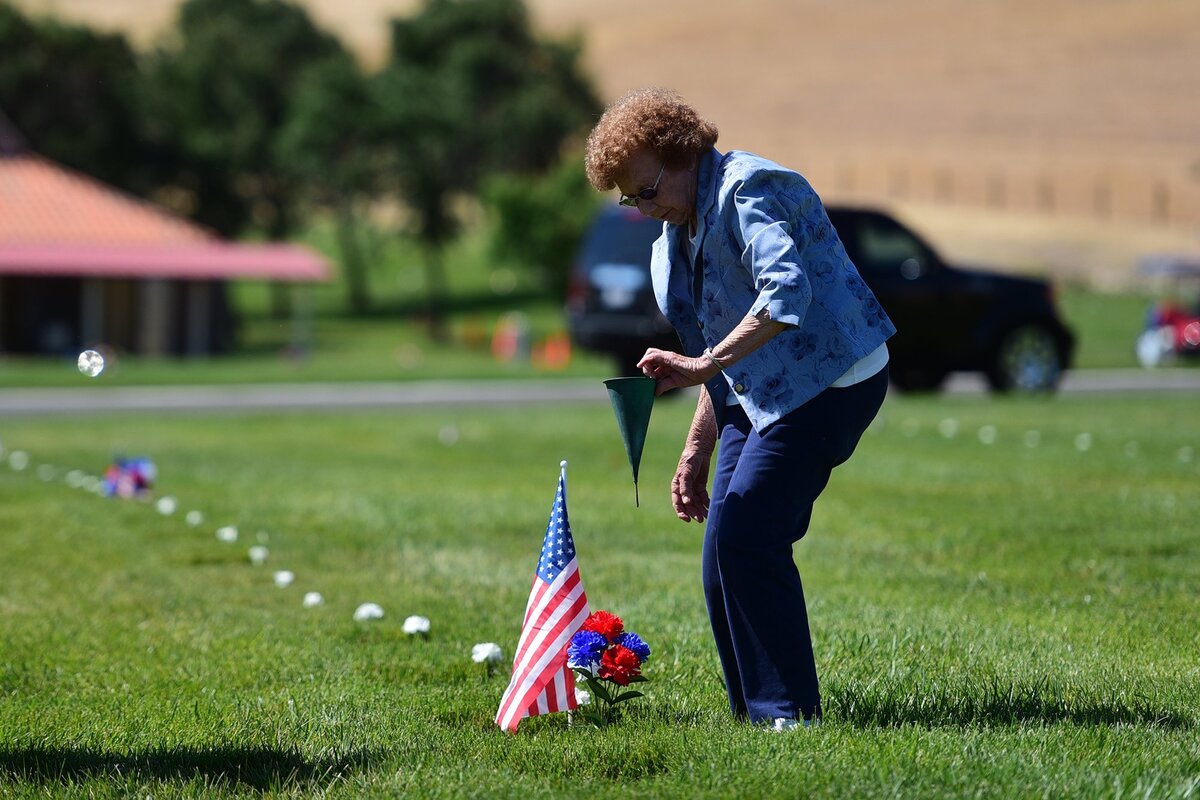 Elma Weaver, 82, of Atwater decorates the headstone of her husband, Ward, on Sunday, May 27, 2018, at San Joaquin Valley National Cemetery in Santa Nella following a ceremony for Memorial Day. The Air Force and Navy veteran who died in 2006 served during the Vietnam and Korea conflicts, his family said.