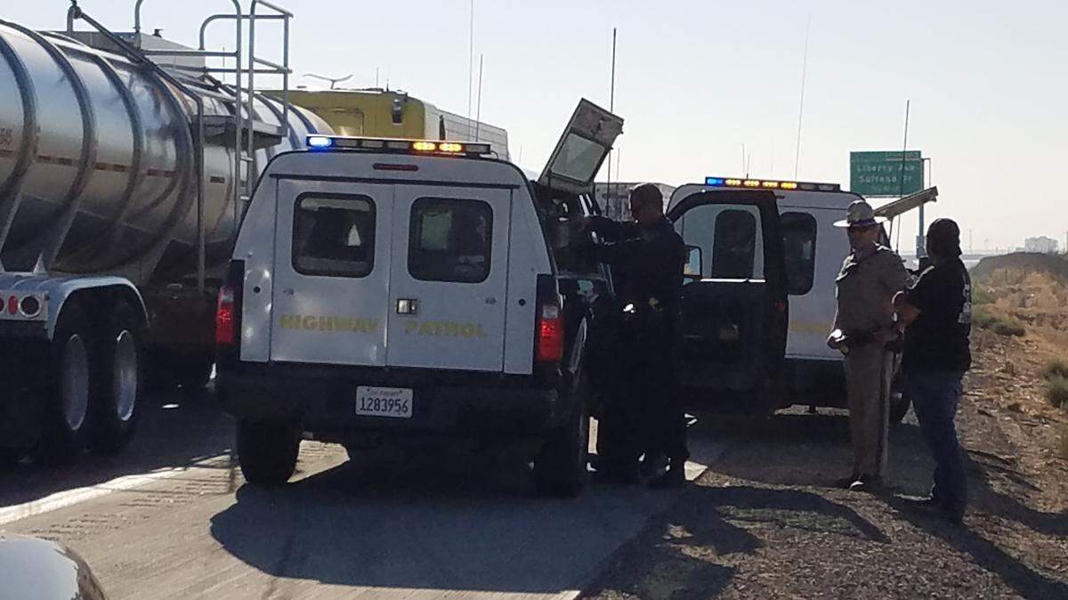 California Highway Patrol officers get ready to clear up the scene of a big rig crash that snarled traffic early Friday, Sept. 7, 2018, on southbound Highway 99, south of Hammatt Avenue.