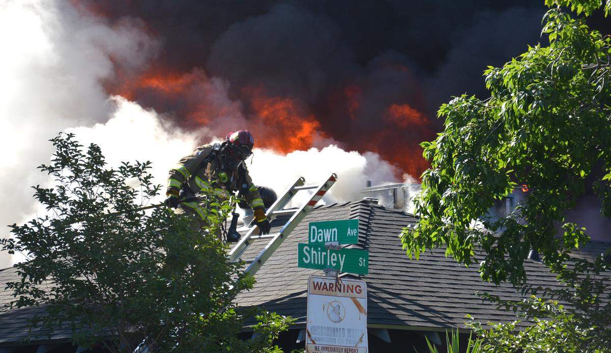 Firefighters battle a large fire that caused explosions and damaged two homes Tuesday, July 23, 2019, at the corner of Shirley Street and Dawn Avenue in Merced.