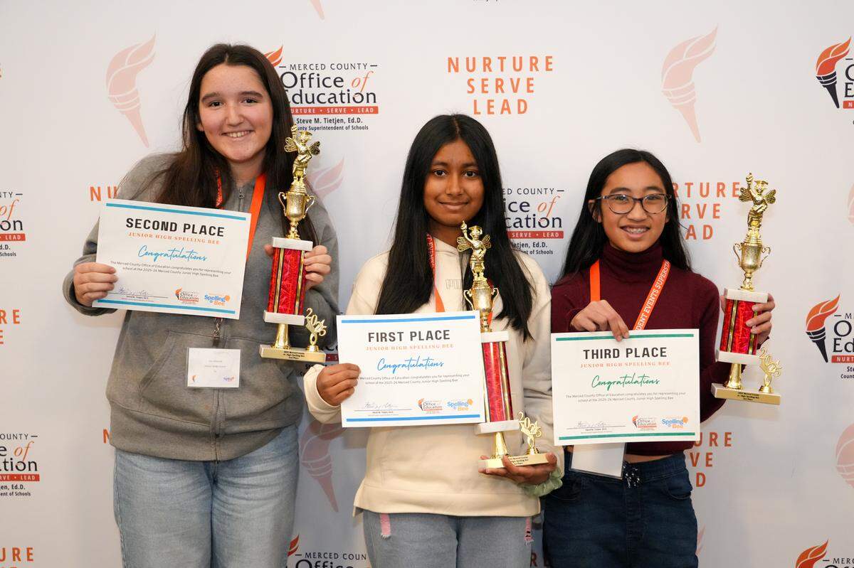 First, second, and third place winners of the Merced County junior high spelling bee stand with their trophies.
