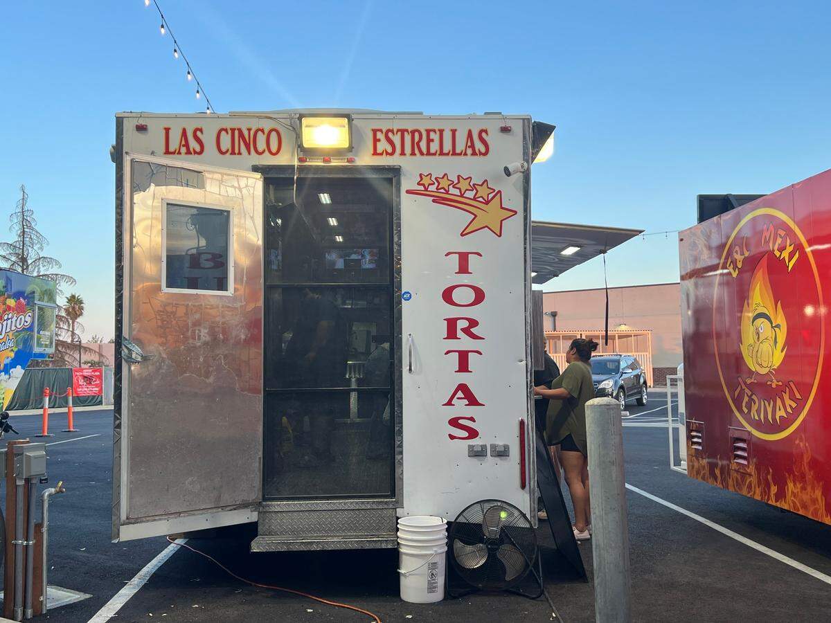 The back and inside of a food truck through a screen door. 