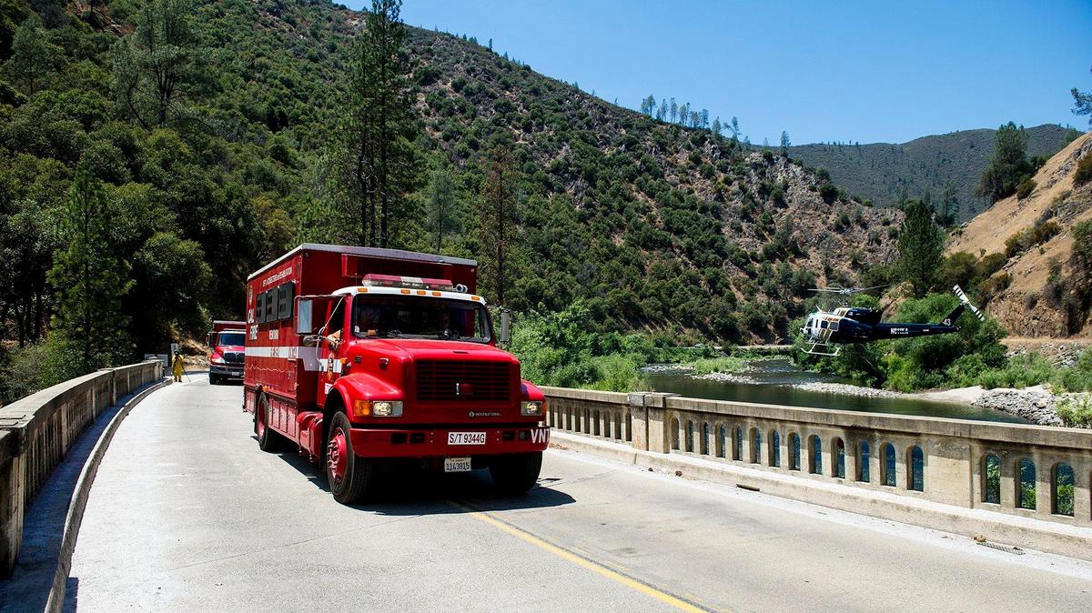 Fire crews drive over the South Fork Merced River bridge on Highway 140 while battling the Ferguson near the Redbud Lodge outside El Portal on Saturday, July 14, 2018. The California Department of Transportation announced Thursday, that it has reopened a 17-mile stretch of road in the Ferguson Fire burn scar area after closing the stretch of road on Wednesday due to an incoming storm. More than 150 cubic yards of debris flow material and one oak tree were removed from the roadway, according to Caltrans.