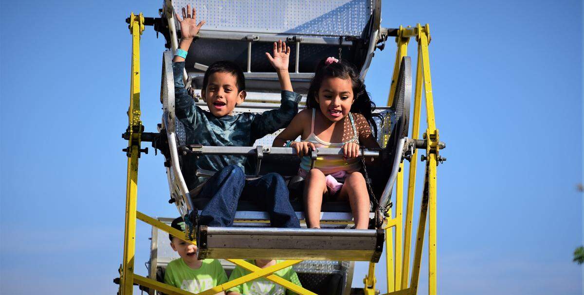 Sebastian Rosales, 7, and cousin Aaliah Alcarez, 6, of Los Banos ride a kid ferris wheel on the opening day of the Merced County Spring Fair in Los Banos on Wednesday, April 27, 2022 in Los Banos, Calif.