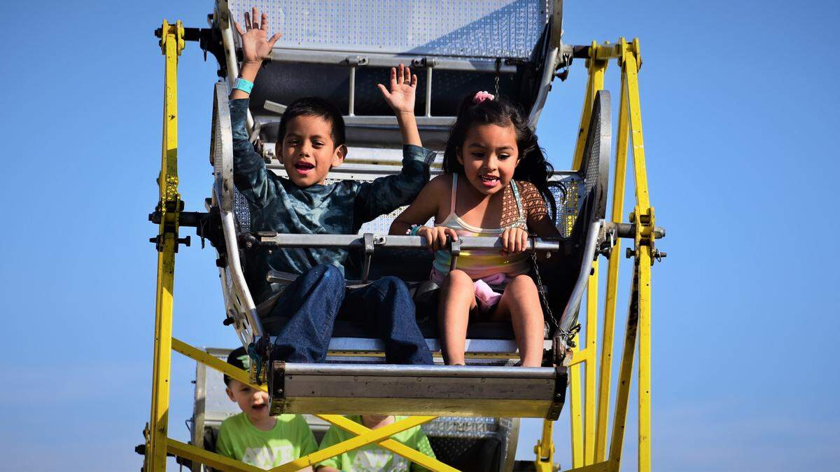 Sebastian Rosales, 7, and cousin Aaliah Alcarez, 6, of Los Banos ride a kid ferris wheel on the opening day of the Merced County Spring Fair in Los Banos on Wednesday, April 27, 2022 in Los Banos, Calif.