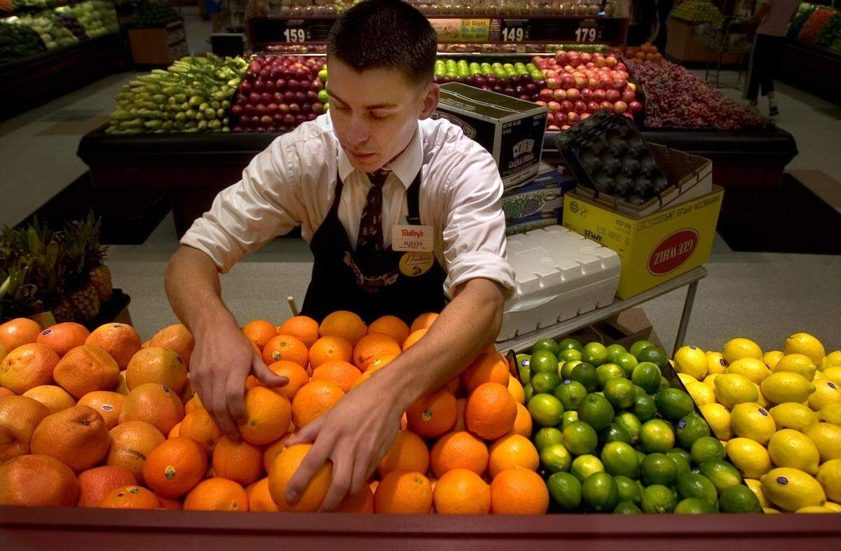A Raley’s produce clerk stocks produce in the grocery store chain’s Granite Bay location. Raley’s stores will be closed on New Year’s Day in 2025.
