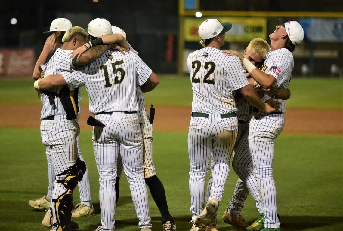 Kingsburg High School players celebrate after winning the Central Section Division III Valley Championship with a 7-5 victory over Dos Palos on Thursday night at Valley Strong Ballpark in Visalia, Calif.