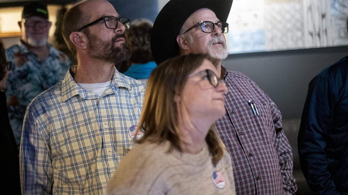 Merced County District 2 Supervisor Josh Pedrozo, left, looks at Primary Election voting results with wife Heidi, center, and father, John, right, in Merced, Calif., on Tuesday, March 5, 2024.
