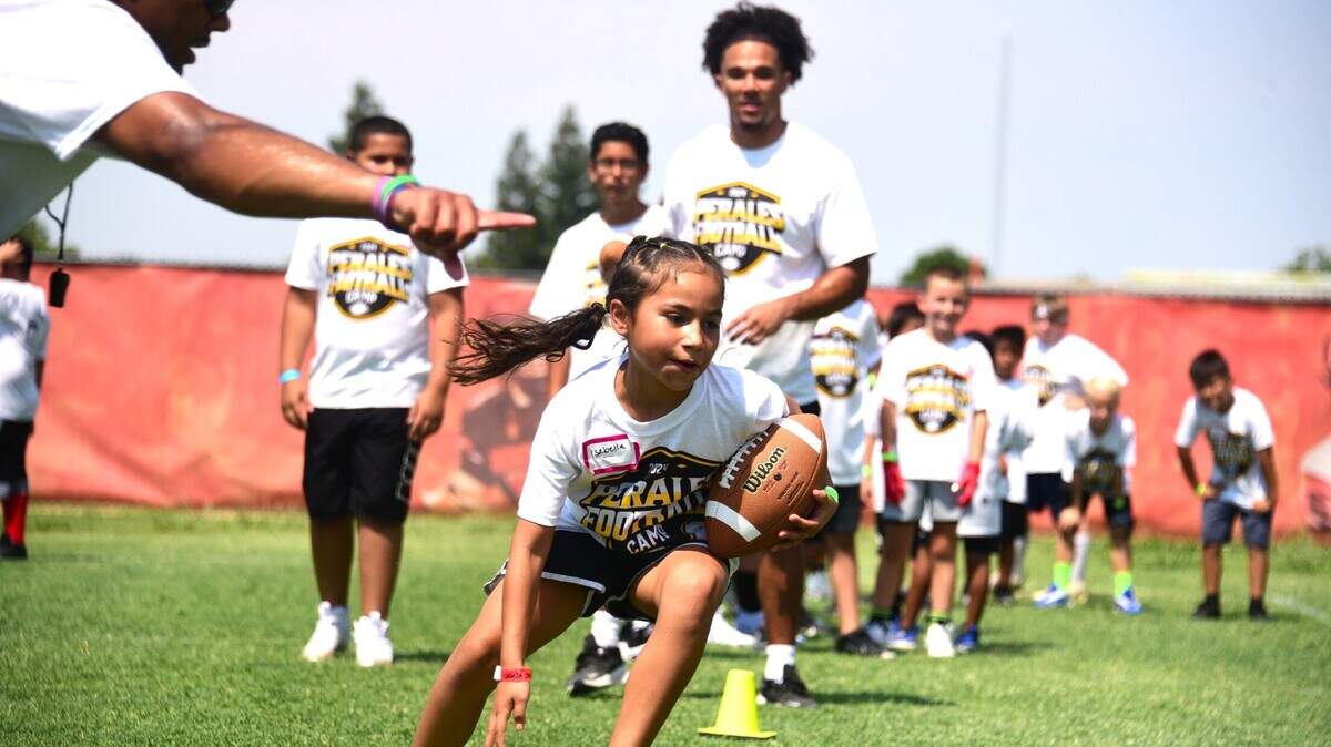 Isabella Chavez, 9, participates in running back drills at the David Perales Football Camp held at Merced High School on Saturday, July 13, 2024 in Merced, Calif.