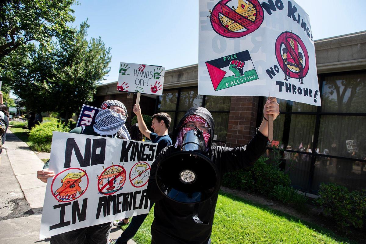 Protesters hold signs and chant into a megaphone as they take part in a “No Kings” protest in Merced, Calif., on Saturday, June 14, 2025.