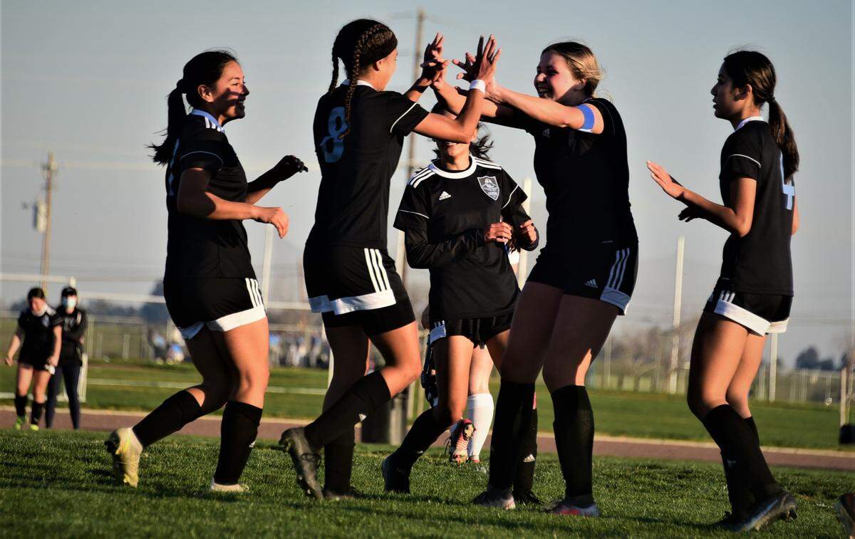 El Capitan High senior Anaya Shelton is congratulated by senior Kassidy Spiva (center) and other teammates after scoring a goal in the second half of a 3-0 win over Sierra on Wednesday, Feb. 16, 2022 at El Capitan High School in Merced, Calif.