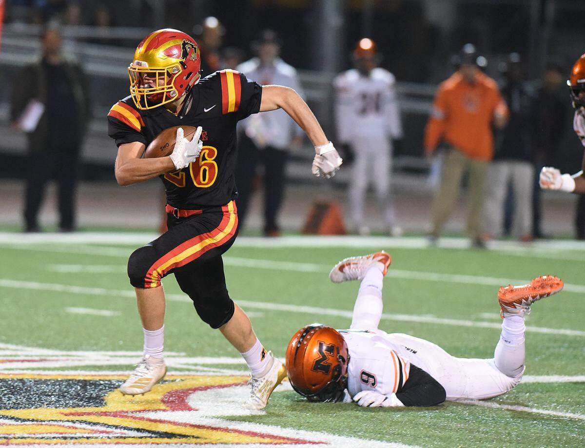 Oakdale running back, Donovan Walker runs away from Merced linebacker, Xavier Ortiz-Wilson in the first quarter, Friday night, Nov. 22, 2019 in Oakdale.