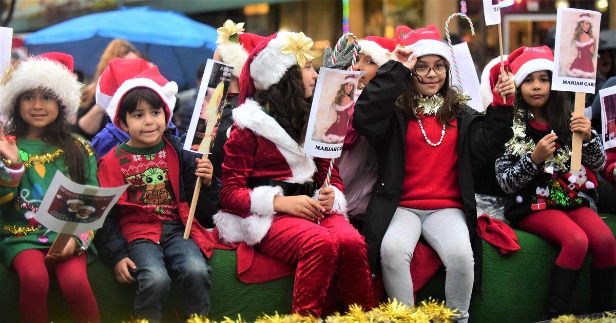Local dancers sit atop a float as they make their way down Main Street during the Merced Christmas Parade on Saturday, Dec. 3, 2022.