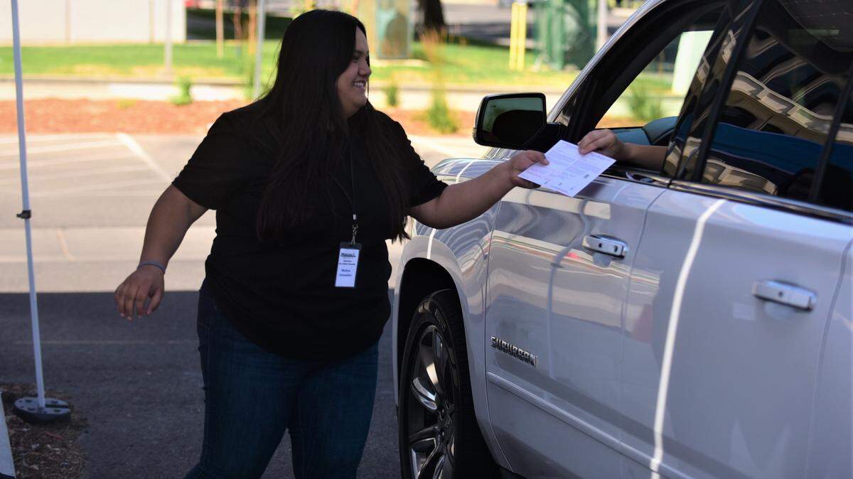 Election worker Melina Gonzales helps a voter submit her ballot at the drive-through ballot dropoff box in front of the Merced County Administration Building on Tuesday, June 7, 2022.