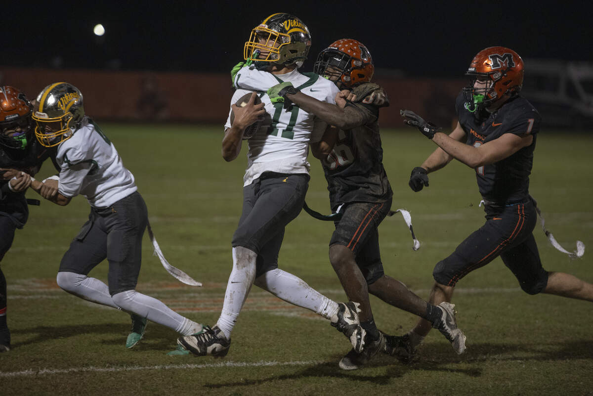 Vanden receiver Kimani Dokes fights for extra yards after a catch while being brought down by Merced defenders during a Division III playoff game on Friday, Nov. 14, 2025. The Vikings held off Merced, 26-25, to advance to the semifinals.