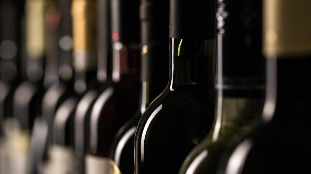 Row of vintage wine bottles in a wine cellar.