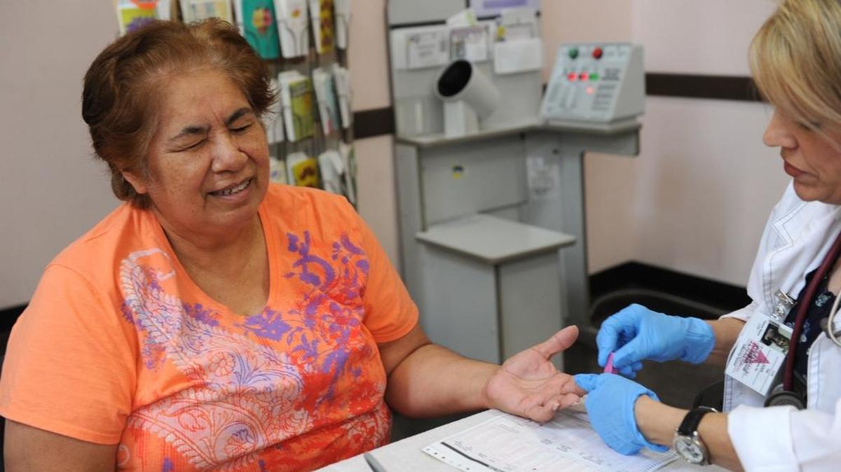 Angie Sandoval, 63, of Merced, grimaces as her finger is pricked for a blood sugar test by Tammy Benyo during a health screening in Atwater in 2013. Women in Merced County are more likely to lack a high-school diploma, struggle to find work, and spend more of their income on child care than women than nearly anywhere else in California, according to a new statewide analysis.
