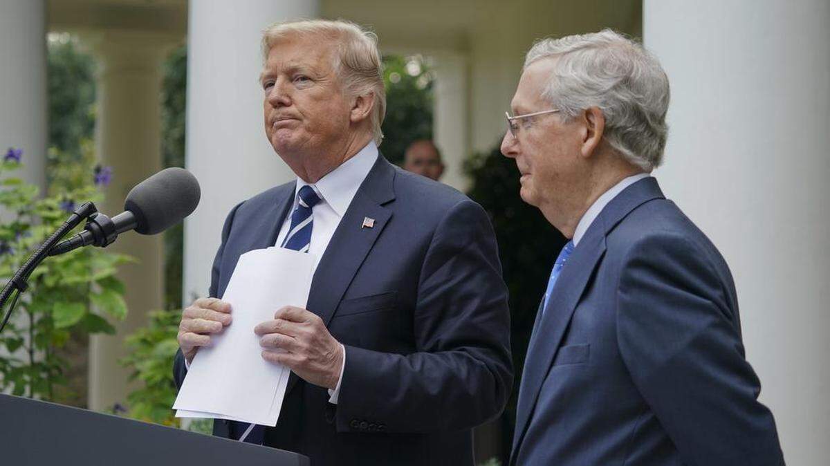President Donald Trump picks up his notes after he and Senate Majority Leader Mitch McConnell of Ky., finish up speaking to members of the media in the Rose Garden of the White House, Monday, Oct. 16, 2017.