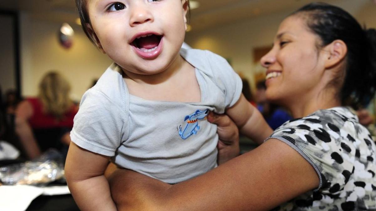 Magdalena Parra holds her son, Adrian Nunez, after receiving an award during the Merced County Breastfeeding Coalition graduation at the Department of Public Health in Merced in 2014.