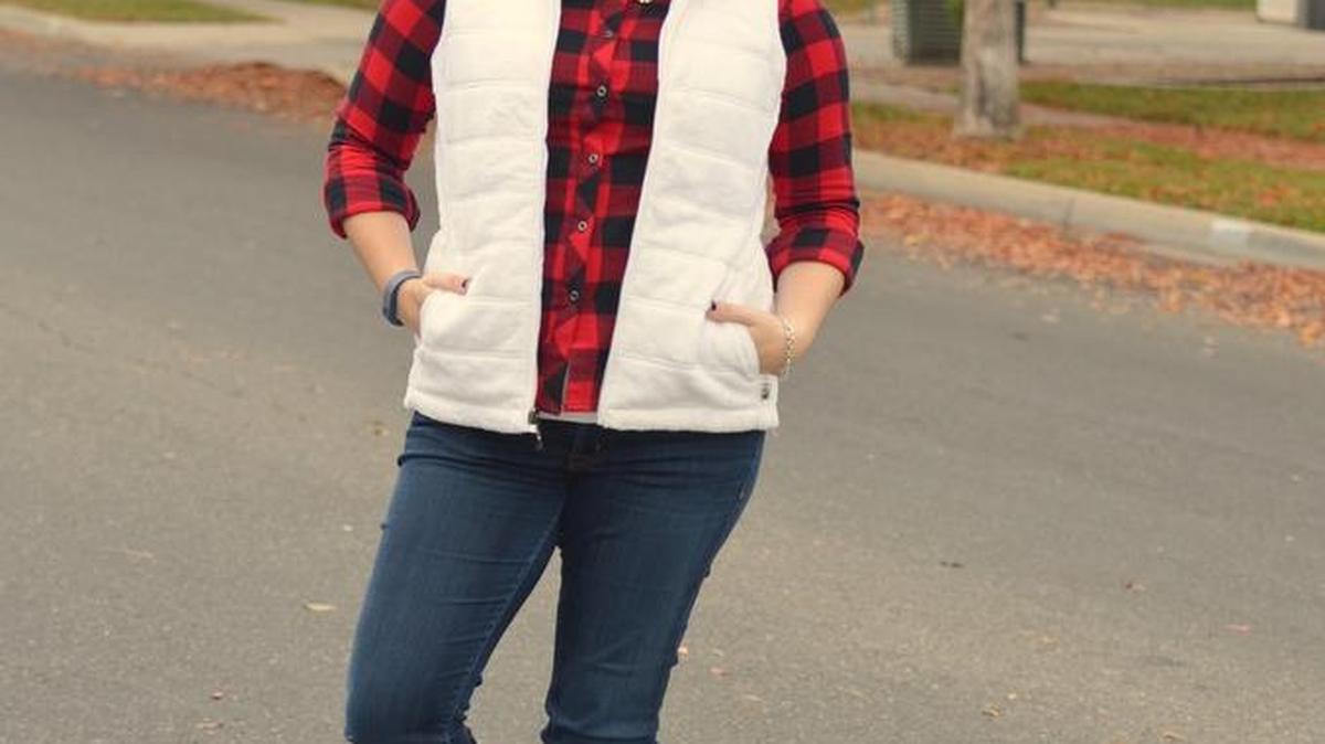 Michelle Oliver pairs a red-and-black plaid shirt from Bass Pro Shops with a white puffer vest, her favorite dark denim jeans and knee-high boots. For sparkle, she added a statement necklace.