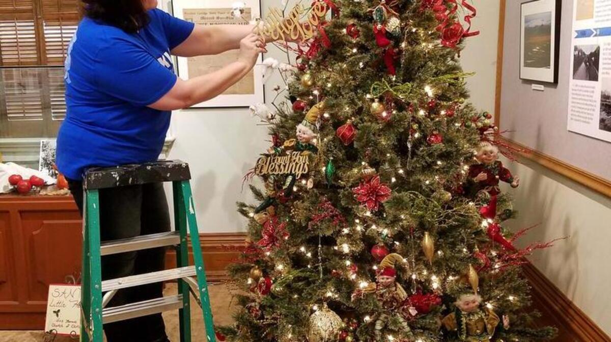 Sandra Strickland of Dos Palos is decorating the Los Banos Church of Christ Christmas tree for the annual Christmas tree display at the Courthouse Museum. (Courthouse Museum Collection)
