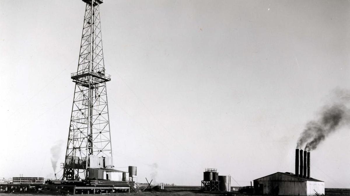 
Oil exploration by Pure Oil Co. took place in El Nido in 1934. This is a general view of the oil well site showing the boiler room and rigging. Gas from the well is being discharged by way of a standpipe to the left of the derrick.
