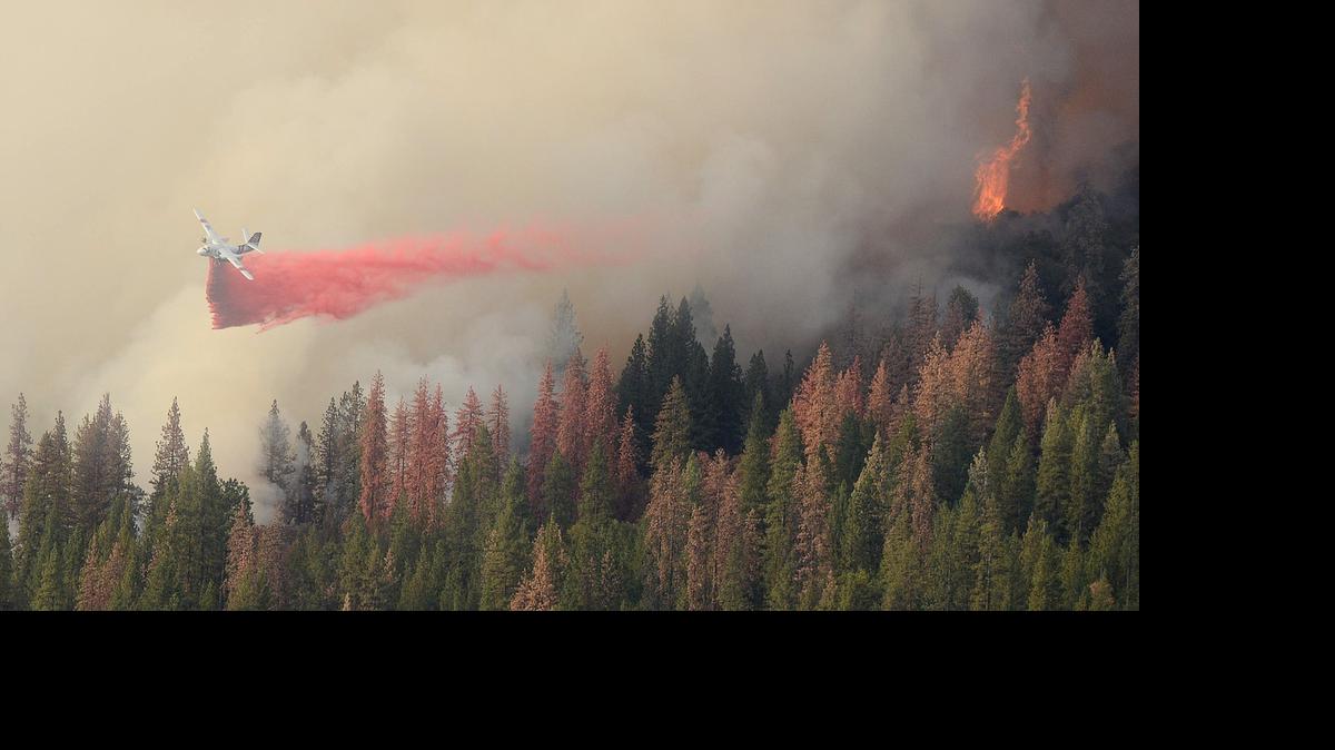 
A tanker drops fire retardant on the front lines of the Willow fire between Bass Lake and North Fork on Saturday.
