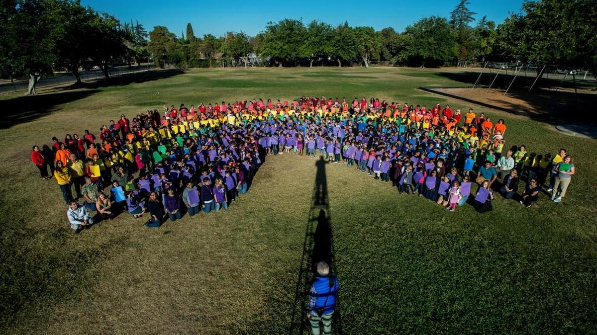 Photographer Michael McLane of Merced directs children and teachers while creating a human rainbow to kick off Red Ribbon Week at Charles Wright Elementary School in Merced on Monday, Oct. 26, 2015.