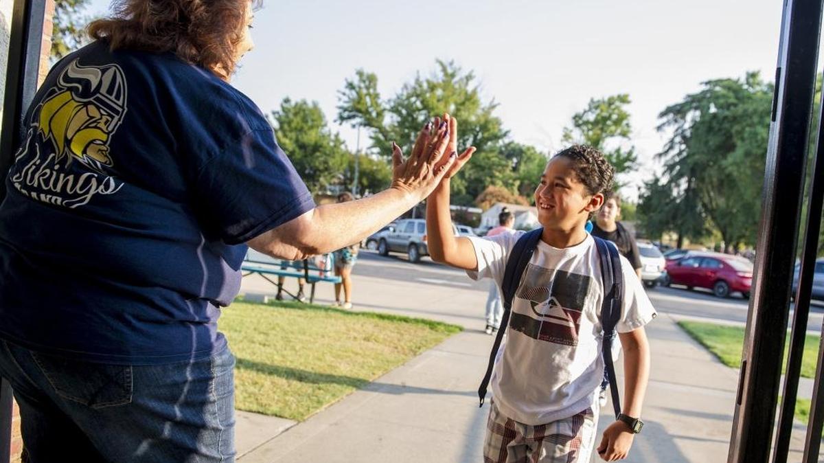 Fifth-grader Cristian Santana, 10, right, high-fives District Chief Business Officer Vicky Bañaga, left, during the first day of school at Le Grand Union Elementary School in at 13071 East Le Grand Rd. in Le Grand, Calif., Wednesday, Aug. 10, 2016.