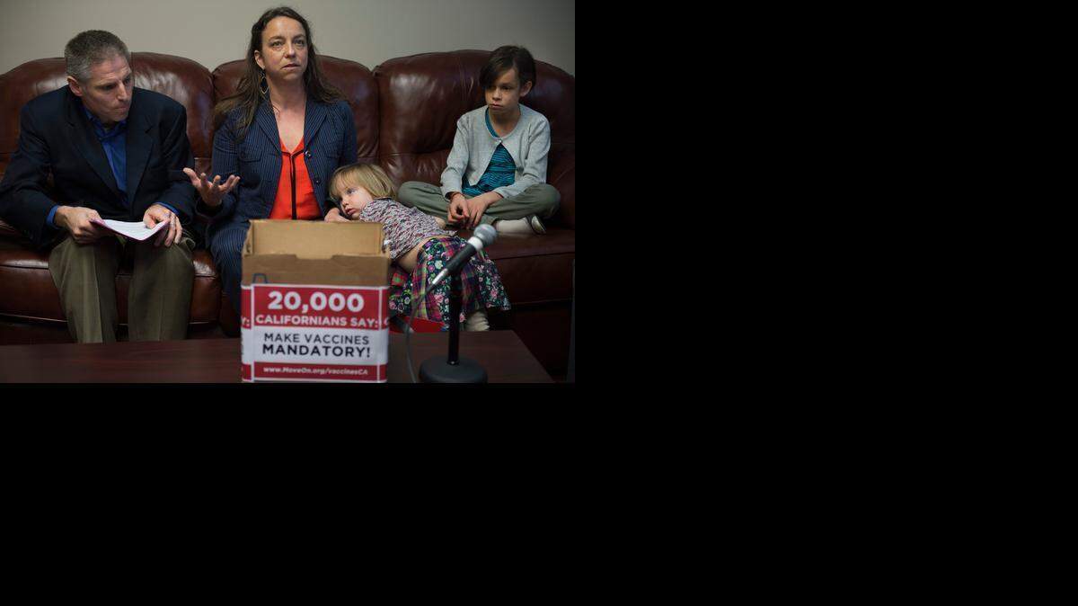 Hannah Henry of Napa, with her children Marjorie Terrien, 2, and Helen Terrien, 10,  and Carl Krawitt,  deliver a box of petitions containing more than 20,000 signatures seeking to require vaccinations for most schoolchildren.