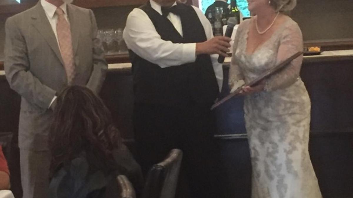 Dr. Joerg Schuller, left, receives a homemade plaque from Carlos Lopez and his new bride, Sheri Lopez. Carlos Lopez credits Schuller with saving his life, saying without Schuller he wouldn’t have lived long enough to marry the love of his life.