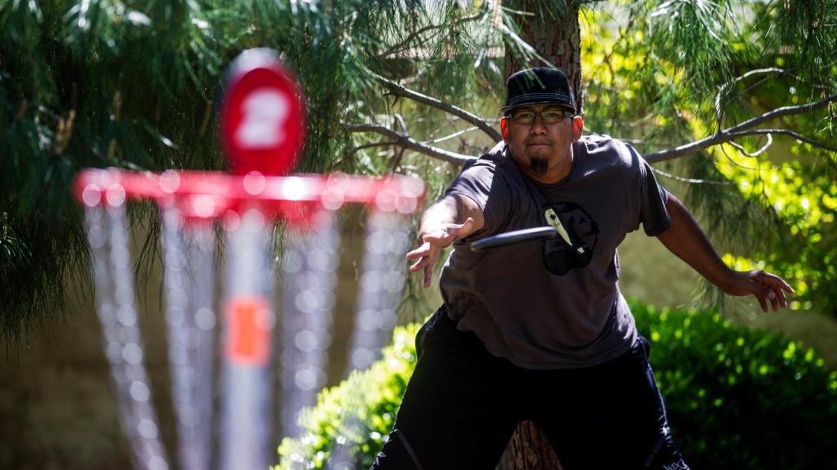 Merced resident Manuel Sanchez, 30, putts while playing disc golf at Fahrens Park in Merced on Wednesday, March 30, 2016.