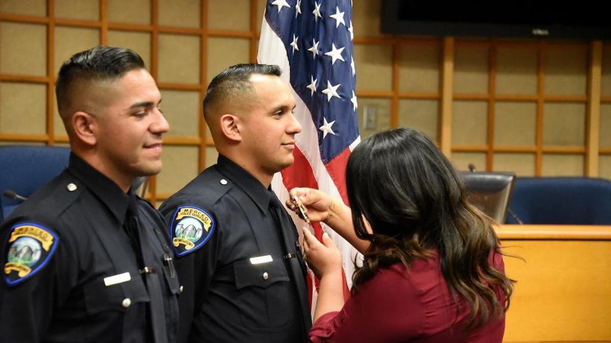 Rocio Bolanos-Dehoyos pins a badge on her husband, Officer Arturo Dehoyos, who was sworn in to the Merced Police Department on Friday, Sept. 23, 2016.