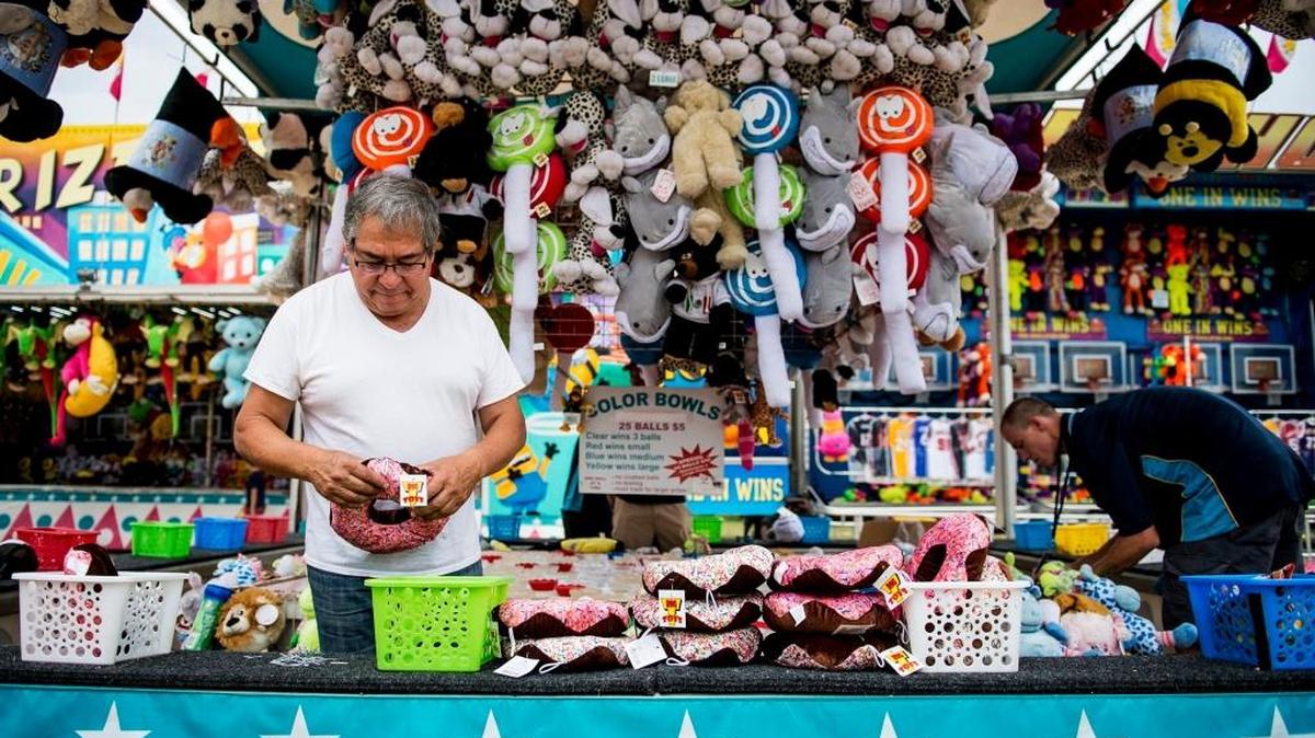 Carnival worker Mario Castro, 64, sorts toys at the Merced County Fair in Merced, Calif., Saturday, June 11, 2016.
