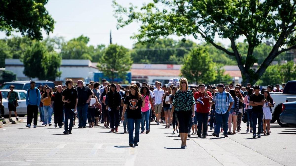 Students make their way back to campus after smoke coming from the kitchen of a culinary class caused a campus evacuation at Merced High School in Merced, Calif., Tuesday, May 17, 2016. According to the chief business officer for Merced Union High School District, John Olson, burning butter caused enough smoke to set off the fire alarm shortly after 10 a.m. while a culinary teacher was preparing a luncheon for classified staff members. There were no visible flames and no injuries have been reported.