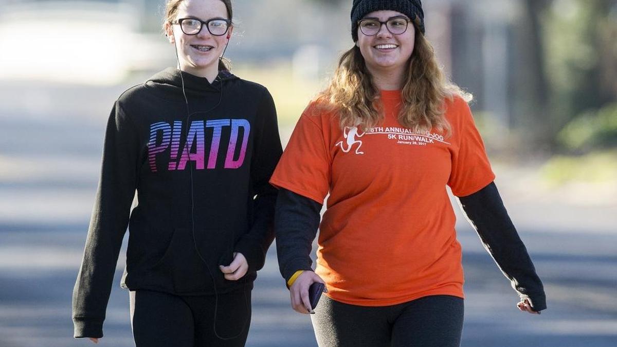 Samantha Frederick, 12, left, and Courtney Mognis, 19, daughter of Brenda Mognis, walk along McKee Road during the annual Mog-Jog 5K Walk/Run in Merced on Saturday.