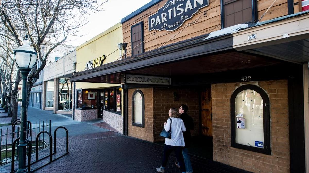 Pedestrians walk past The Partisan, a bar at 432 W. Main St., on Thursday, Dec. 31, 2015. The establishment has been closed for renovation since March.