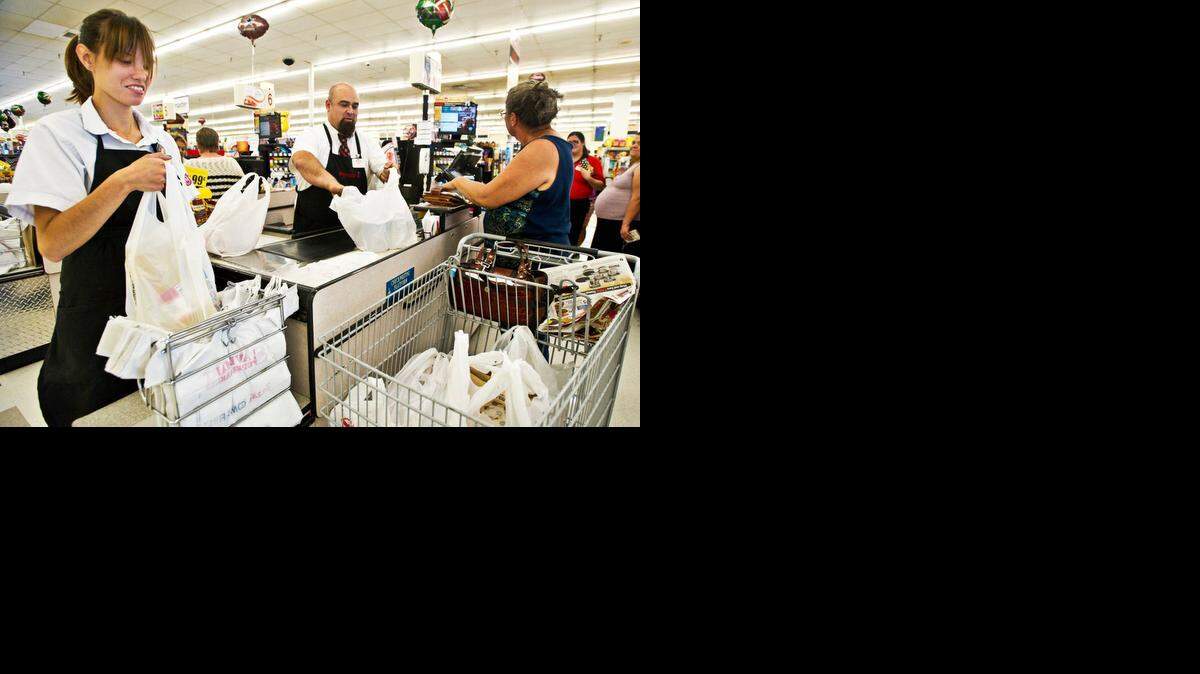 
Workers bag a customer’s purchases at the SaveMart grocery store in Merced. Save Mart’s deal with Local 8 restores some of the concessions the union made to the Modesto grocer two years ago, according to an announcement on a union website. 
