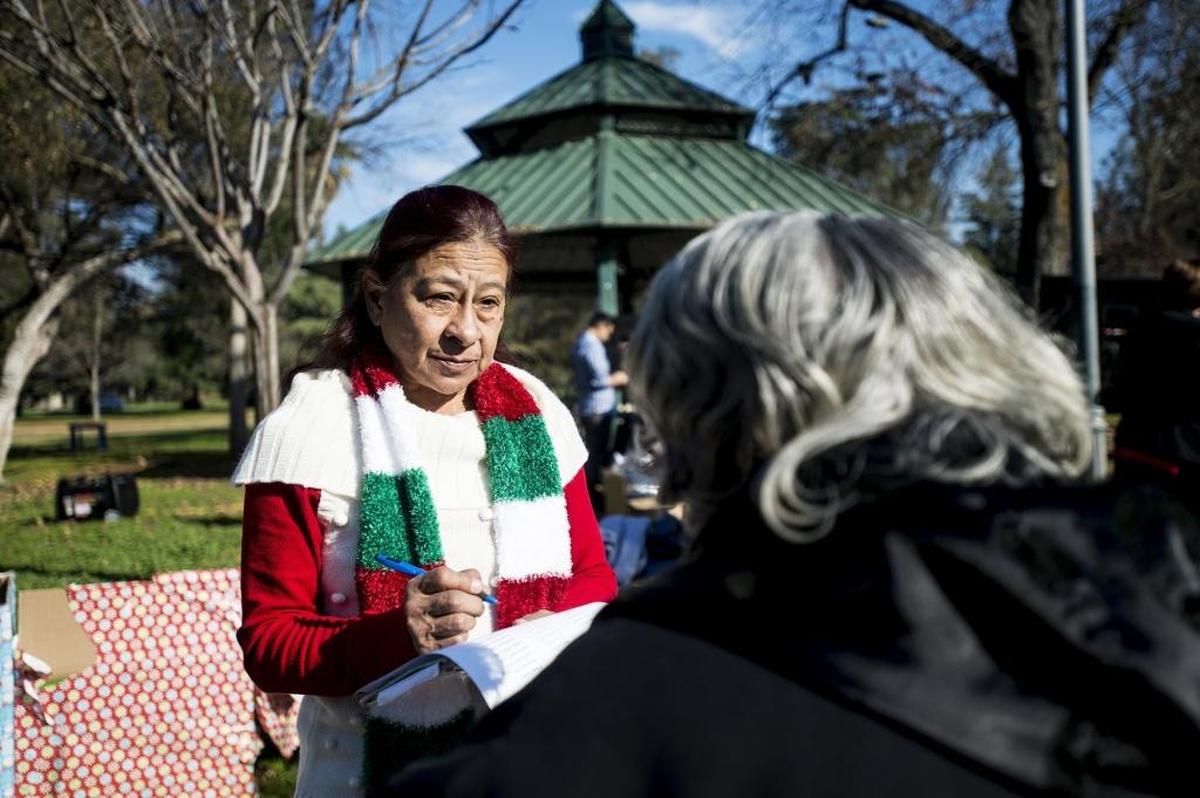 Monica K. Villa, 61, of Merced adds the names of homeless people who have died to a list that was read aloud Wednesday in their memory at Applegate Park in Merced. Food and clothing were available during the service.