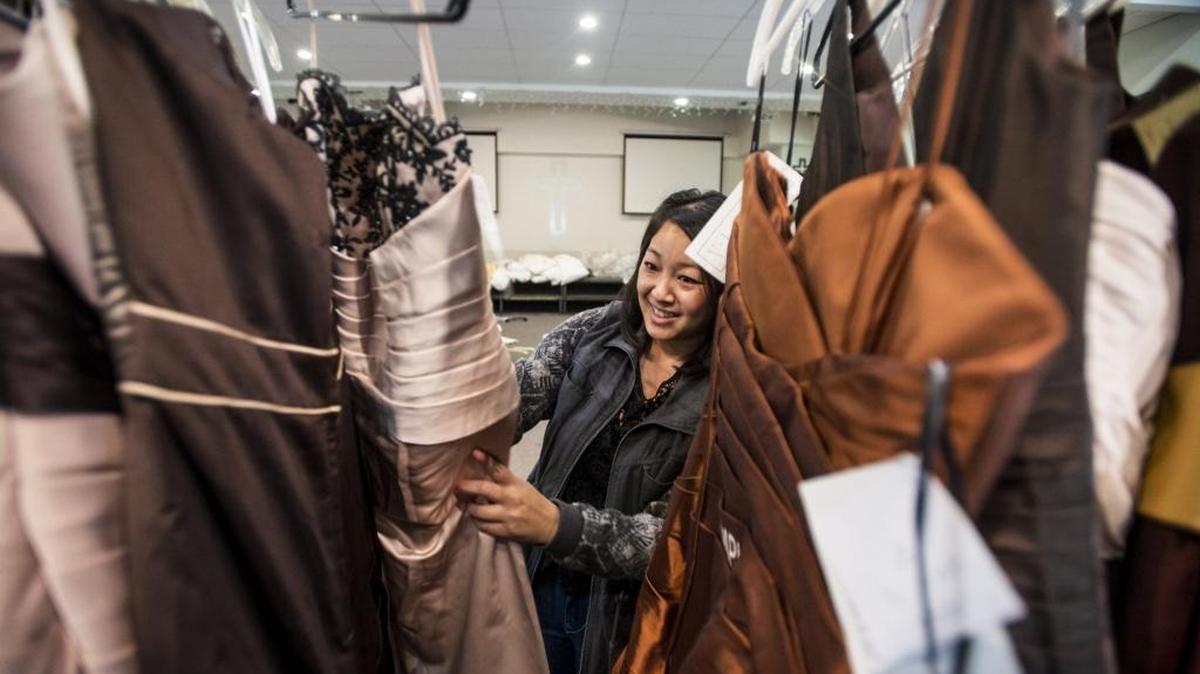 Laura Thor, 34, of Appleton, Wis., arranges dresses on a rack as Project Prom organizers sort donated prom dresses at the Alliance Church of Merced on Friday, March 11, 2016. The Bay Area chapter of Hmong Women Today has received over 2,000 donated dresses that will be given to girls for free during Project Prom on Saturday, March 12, at Alliance Church in Merced.
