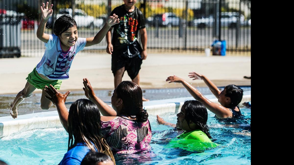 
Dulce Maria Mendez, 4, of Merced leaps into the arms of her mother, Laura Ramirez, at the McNamara Community Park pool in Merced on Thursday.
