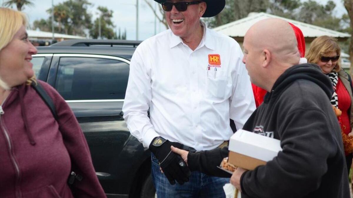 Greg Hostetler shares a laugh with grateful recipients during Hostetler Farms’ and Joseph Farms’ turkey, almond and cheese giveaway in Los Banos in 2014.