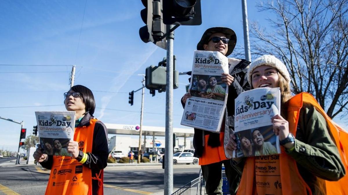 Merced High School students, from left, Andrew Kim, 18; Dang Luong, 18; and Quinn Hagerman, 16, sell Kids Day editions of The Fresno Bee at G Street and Olive Avenue in Merced on Tuesday. Proceeds from the special-edition newspaper go to Valley Children’s Hospital in Madera.