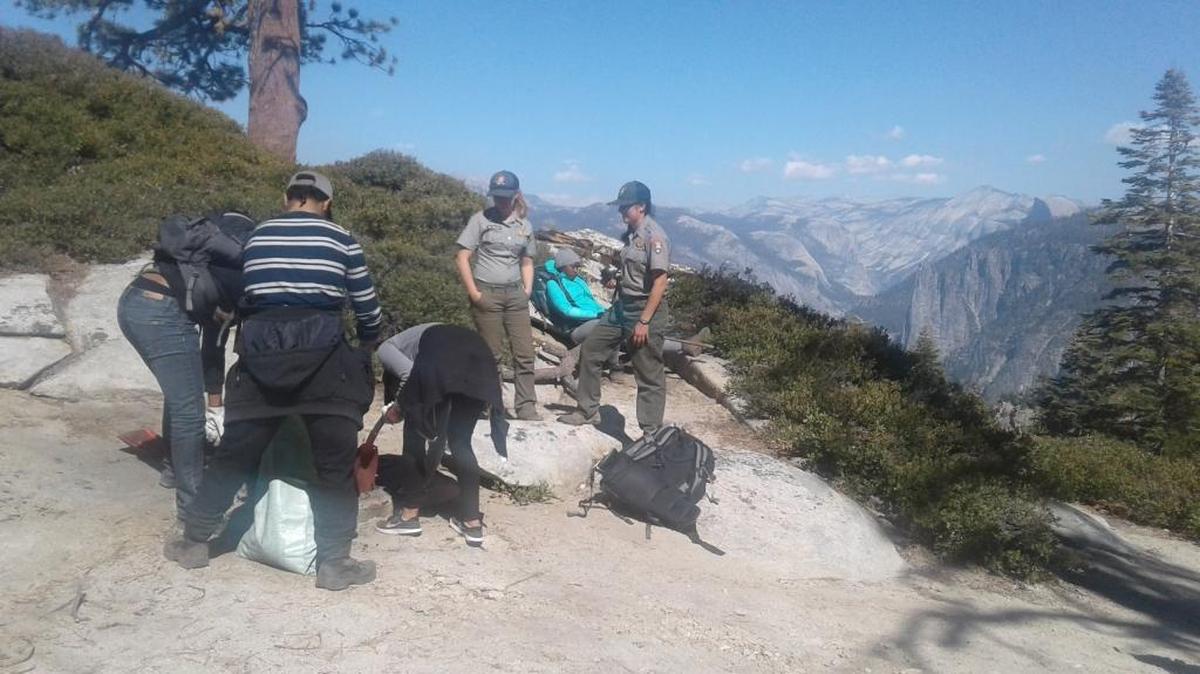 Yosemite High School students and Yosemite park rangers clean out a fire ring at Yosemite National Park.