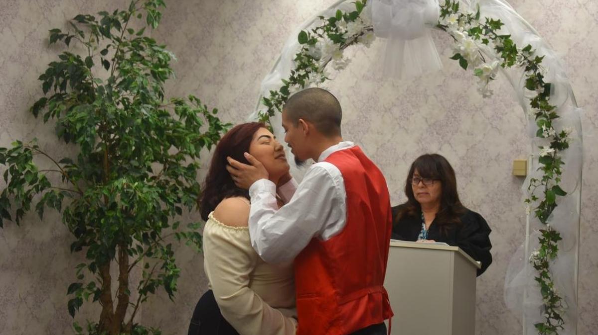 Kyla Dennison, 19, and Isaac Zuniga, 20, kiss during their wedding ceremony in the Merced County Administration Building on Tuesday. They were married by deputy clerk Lea Hernandez and were accompanied by their two daughters, friends and family.