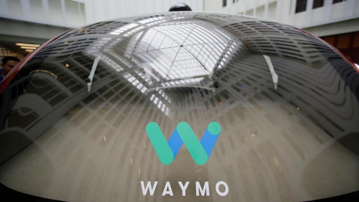 A skylight is reflected in the rear window of a Waymo driverless car during a Google event Tuesday in San Francisco. The self-driving car project that Google started seven years ago has grown into a company called Waymo. The new identity announced Tuesday marks another step in an effort to revolutionize the way people get around. Instead of driving themselves, people will be chauffeured in robot-controlled vehicles if Waymo, automakers and ride-hailing service Uber realize their vision within the next few years.